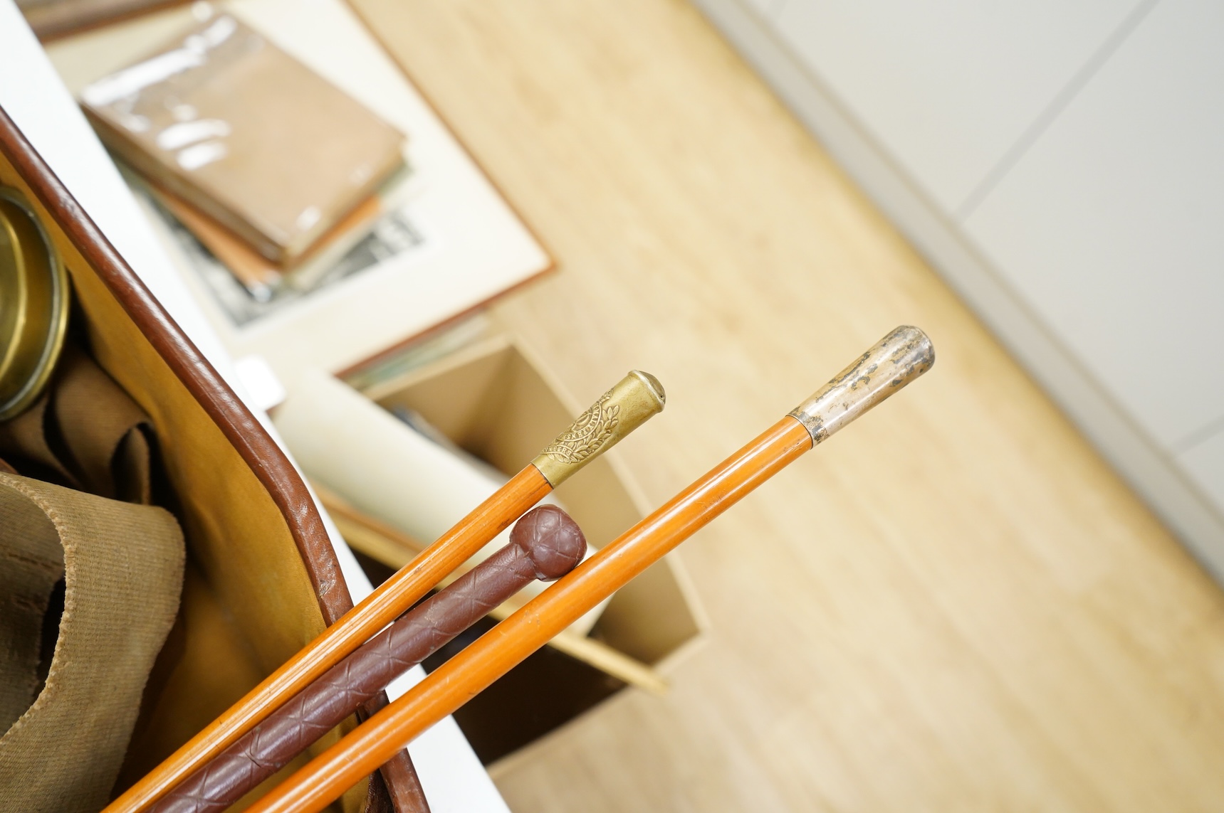 A suitcase of military related items, including; a Manchester Guardian issued early 20th century map of Europe printed on cotton, a First World War trench art match holder the base formed from a cartridge case, two swagg